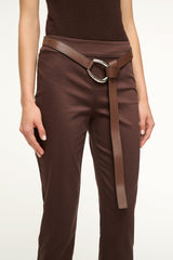 Mahogany brown wrap belt at waist with silver oval buckle on dark trousers