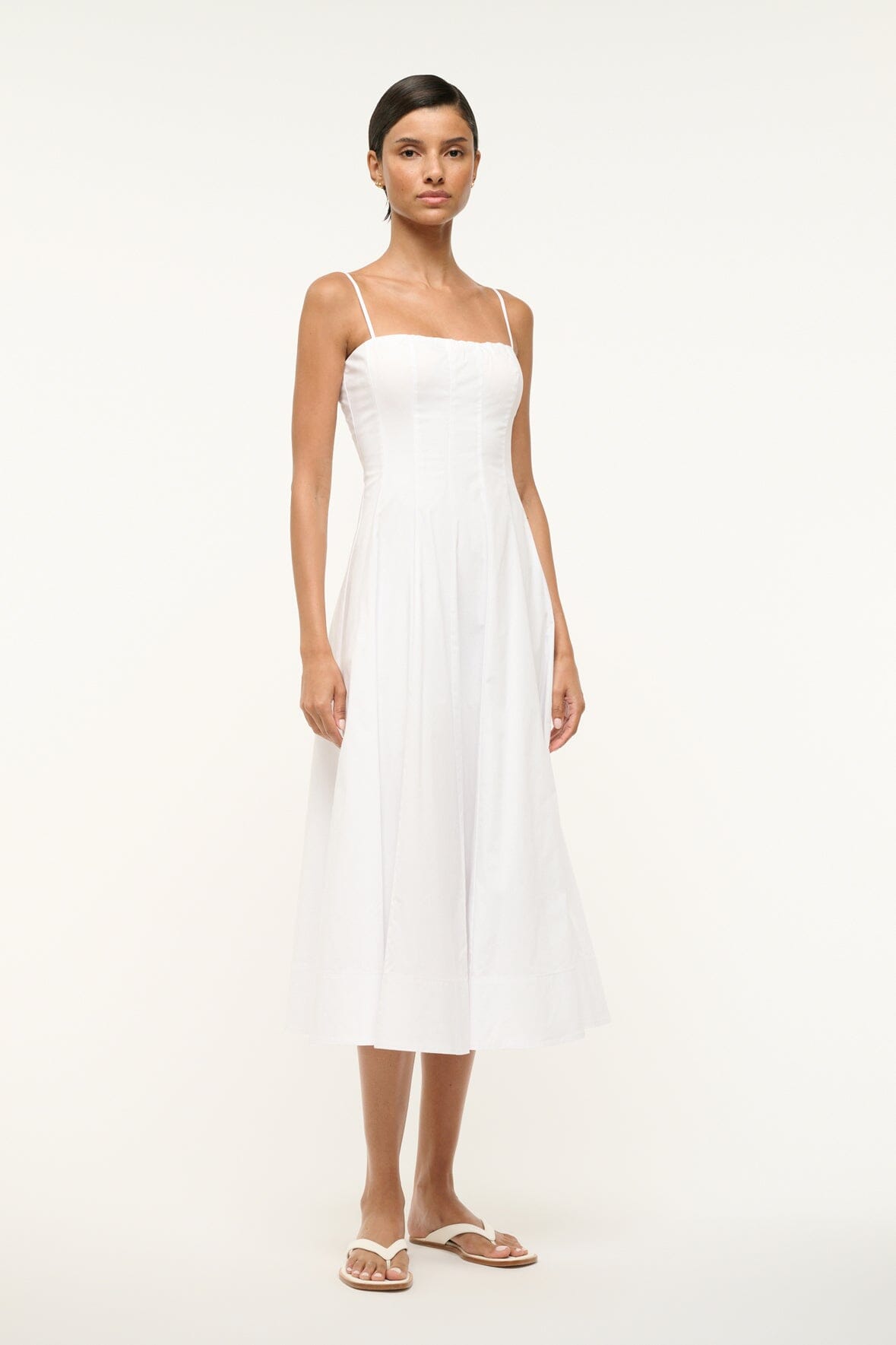 White midi dress with thin straps and softly pleated flared skirt