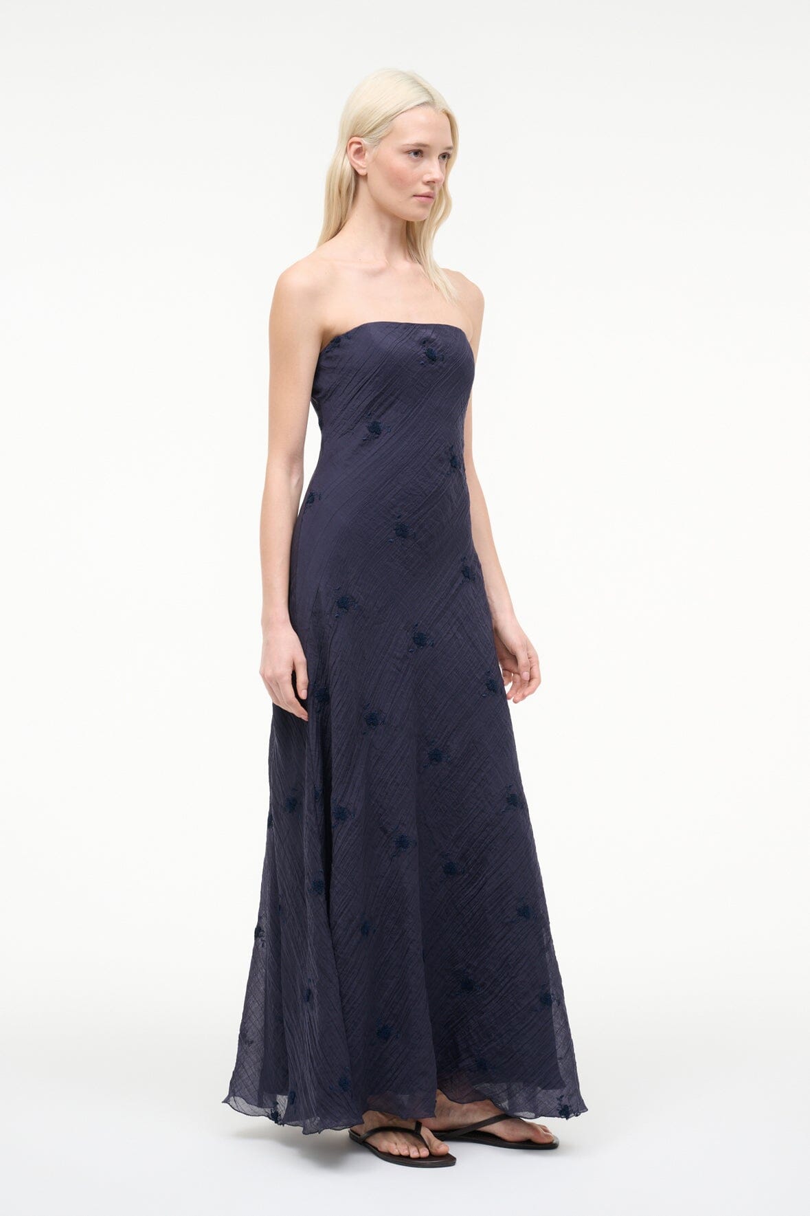 Navy strapless maxi dress with scattered dot pattern and draped full skirt