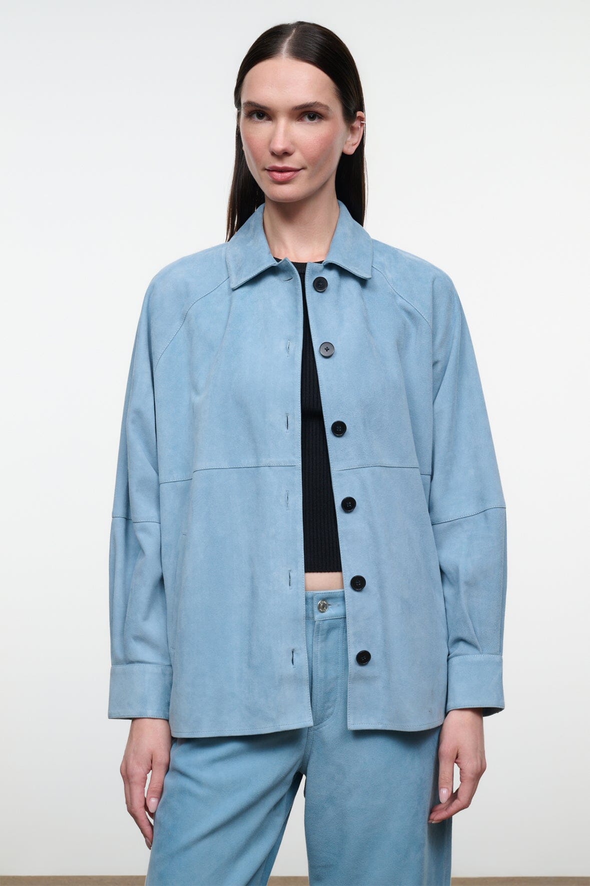 Sky-blue suede shirt with point collar, black buttons, chest patch pockets; long sleeves