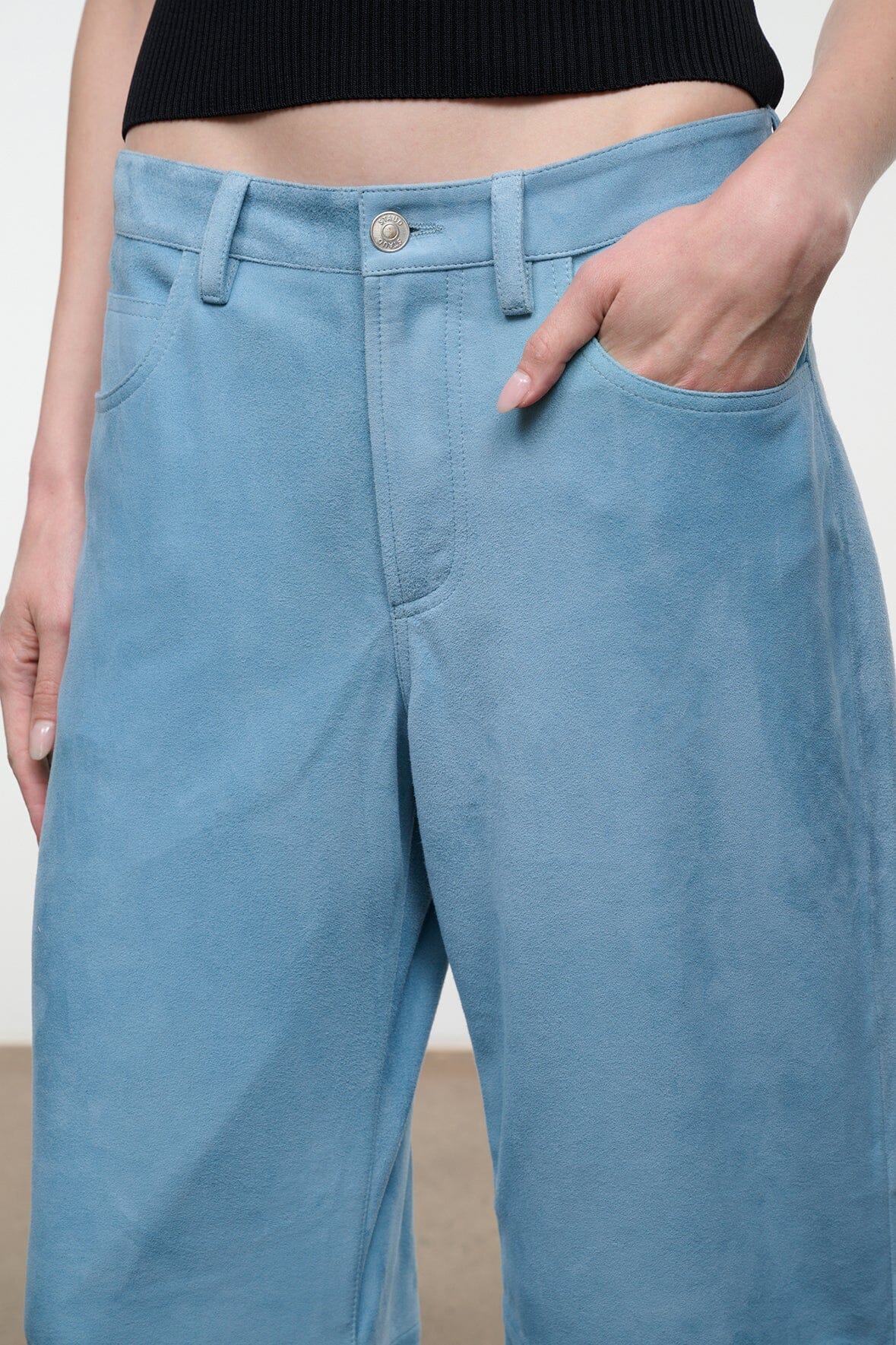 Sky blue suede pants with button closure, belt loops, and front slash pockets.