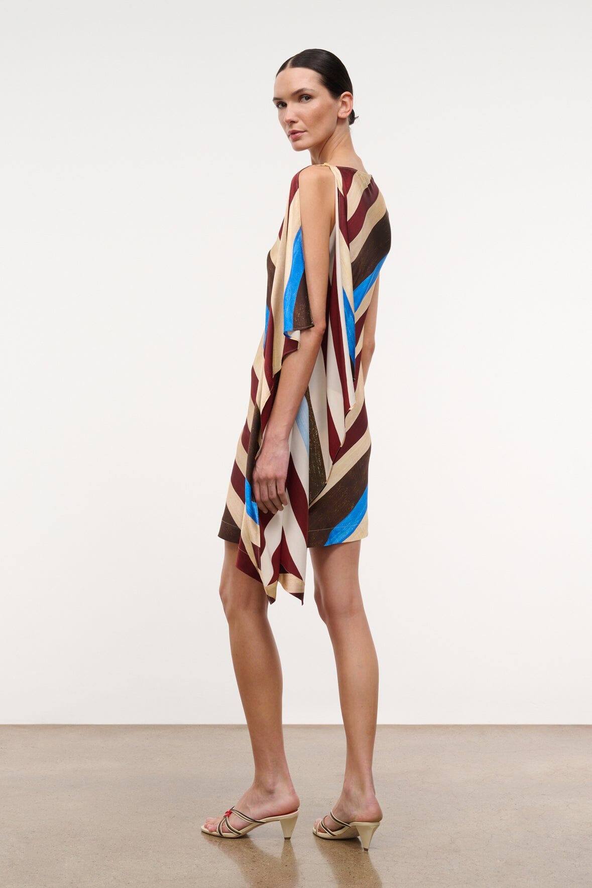 Sleeveless silk dress with asymmetrical drape hem in striped brown, cream, burgundy, blue