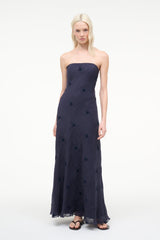Navy strapless maxi dress with fitted bust and dark dot print, flowing hem
