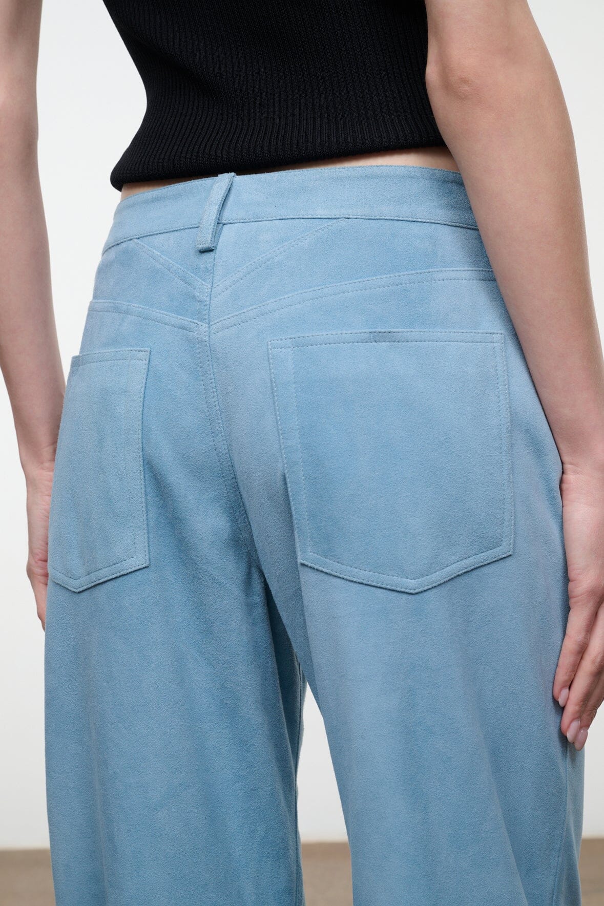 Sky blue suede pants with back patch pockets and wide straight legs.