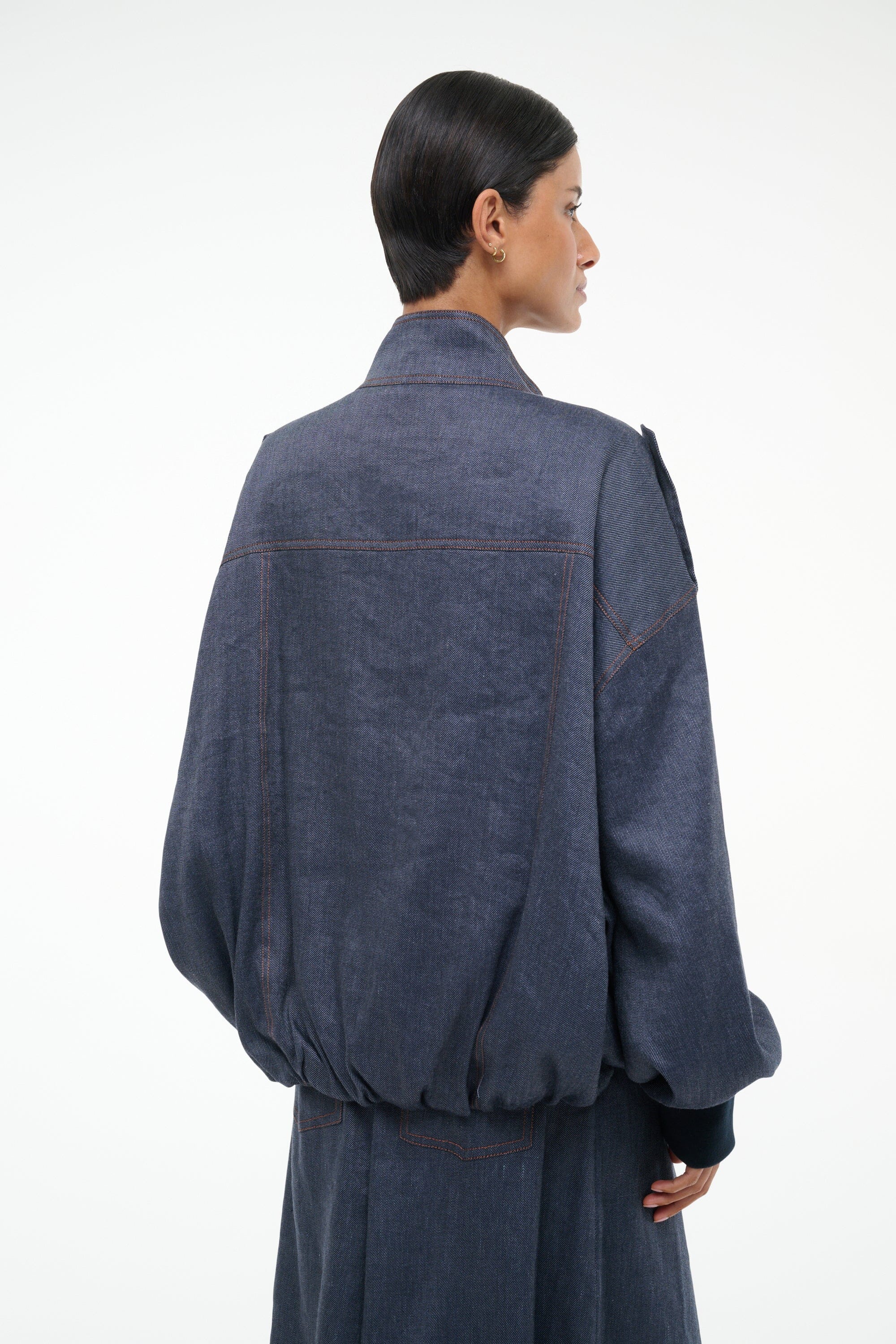 Dark blue chambray jacket back view with yoke seam and ribbed buttoned cuffs
