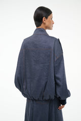 Dark blue chambray jacket back view with yoke seam and ribbed buttoned cuffs