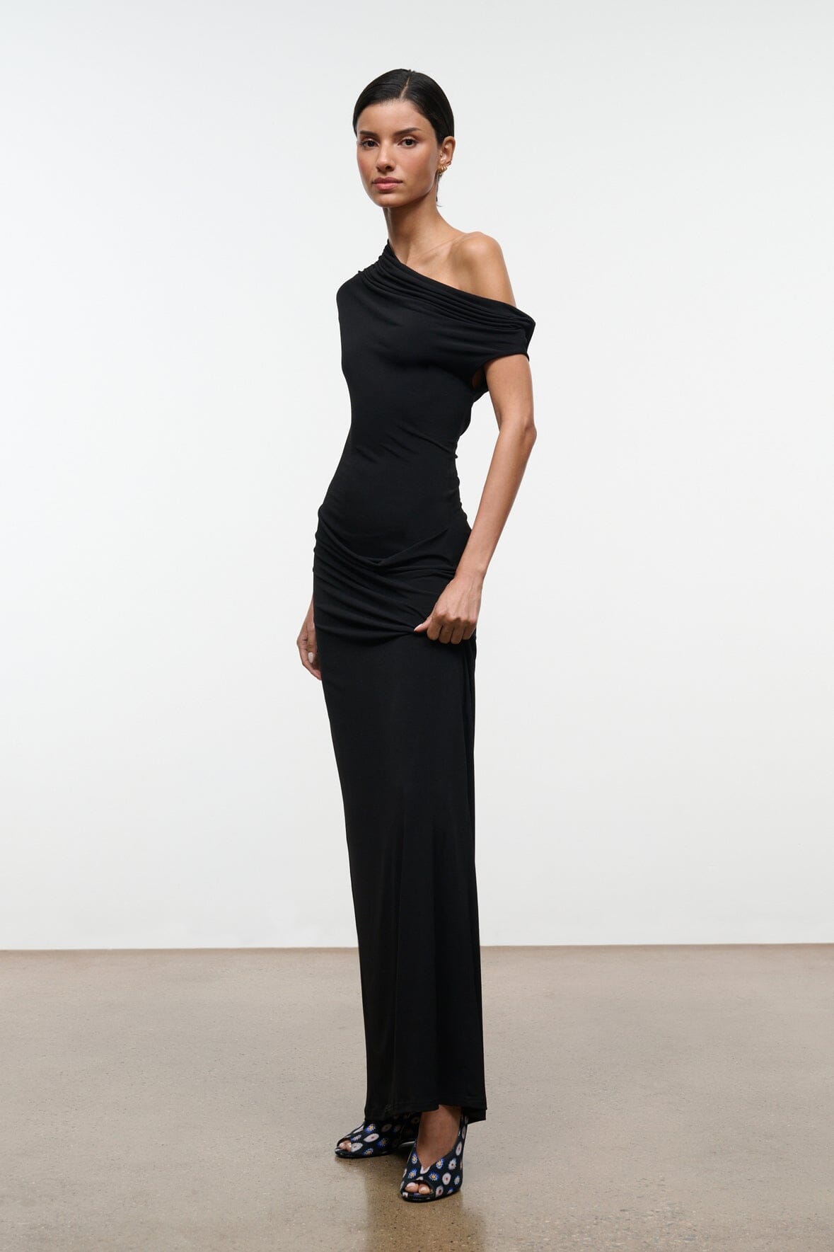 Black one-shoulder draped maxi dress, sleeveless, front-side view, floor-length length