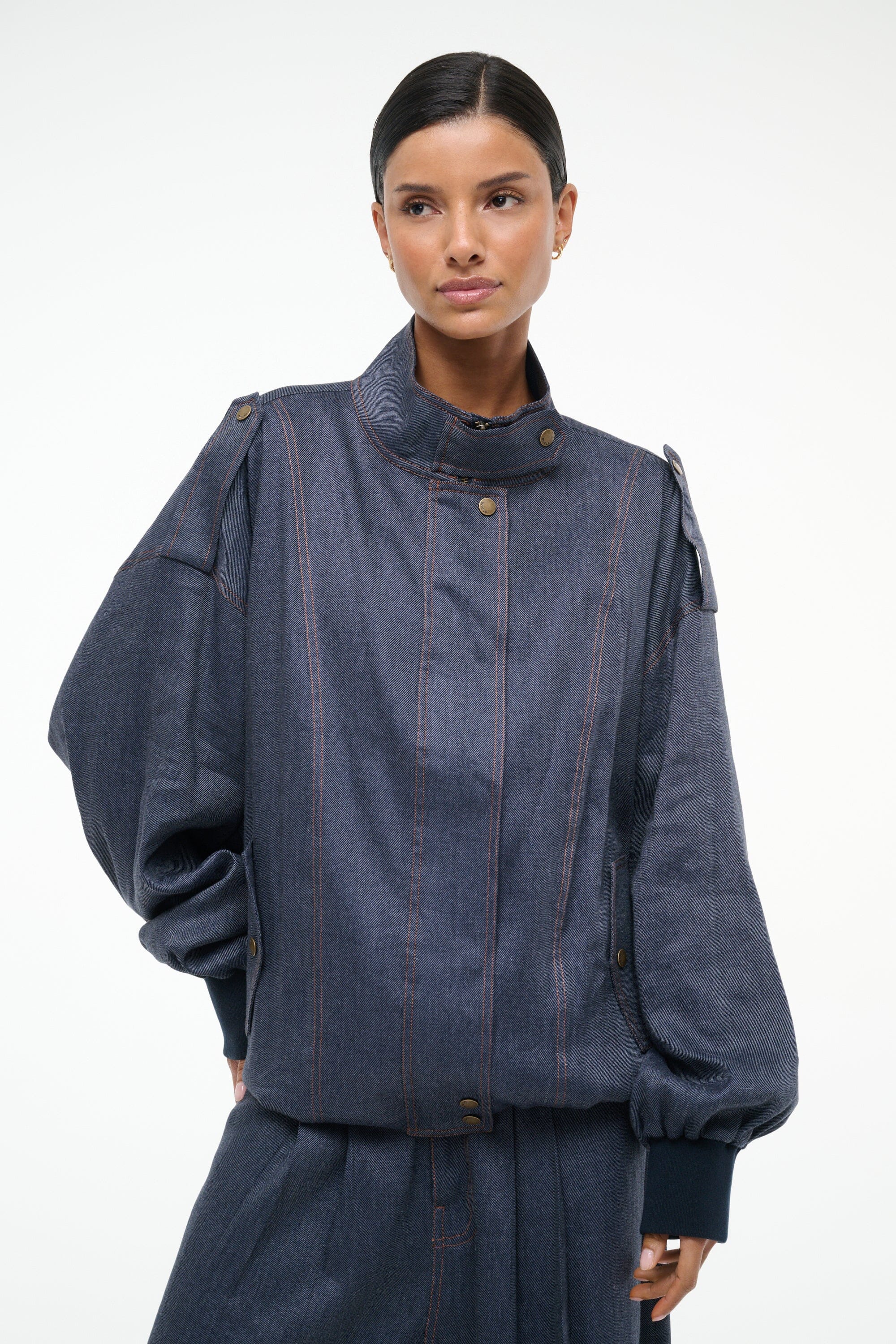 Dark blue chambray jacket with high collar, vertical stitch stripes, and snap buttons