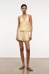 Butter linen halter top with V neckline and gathered peplum hem