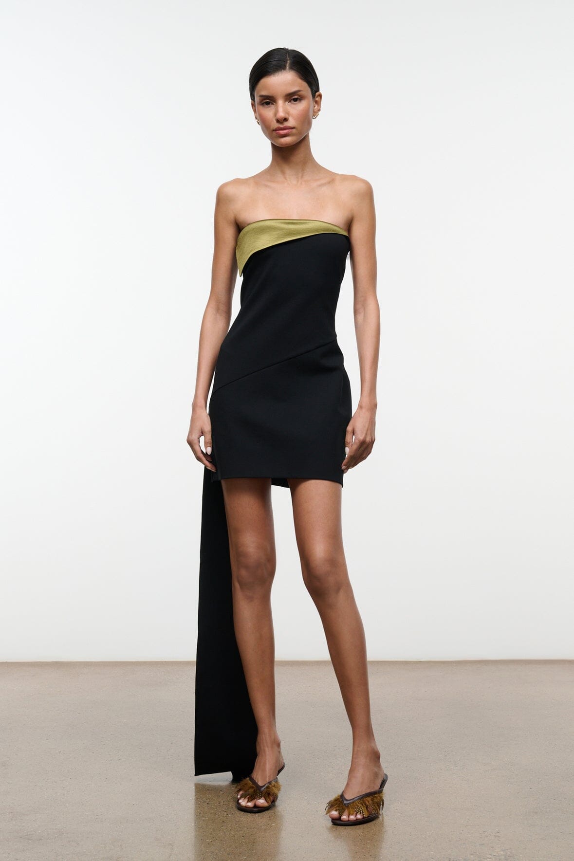Strapless black mini dress with olive-gold neckline band and side seam detail