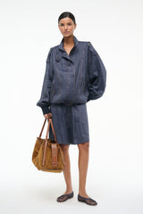 Dark blue chambray jacket with snap-button front, bomber-style cuffs, and patch pockets