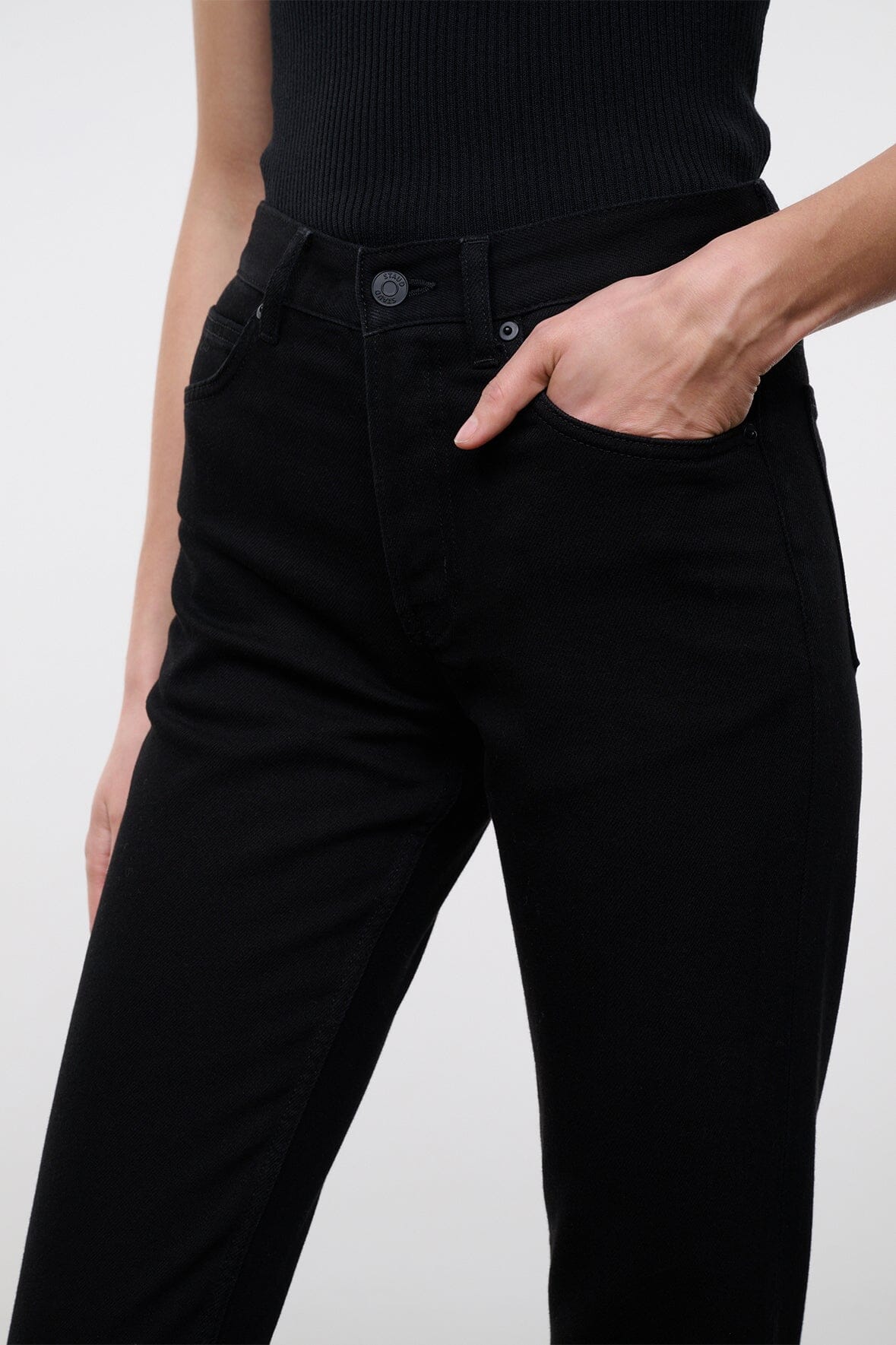 Close-up of black denim jeans waistband with button and belt loops