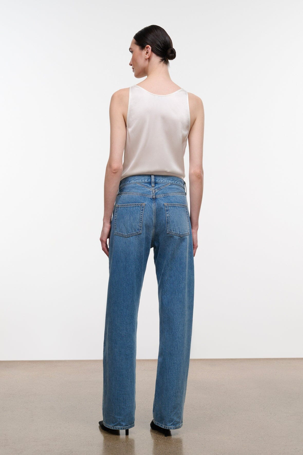 Medium-wash boyfriend jeans with wide legs, belt loops, and back yoke