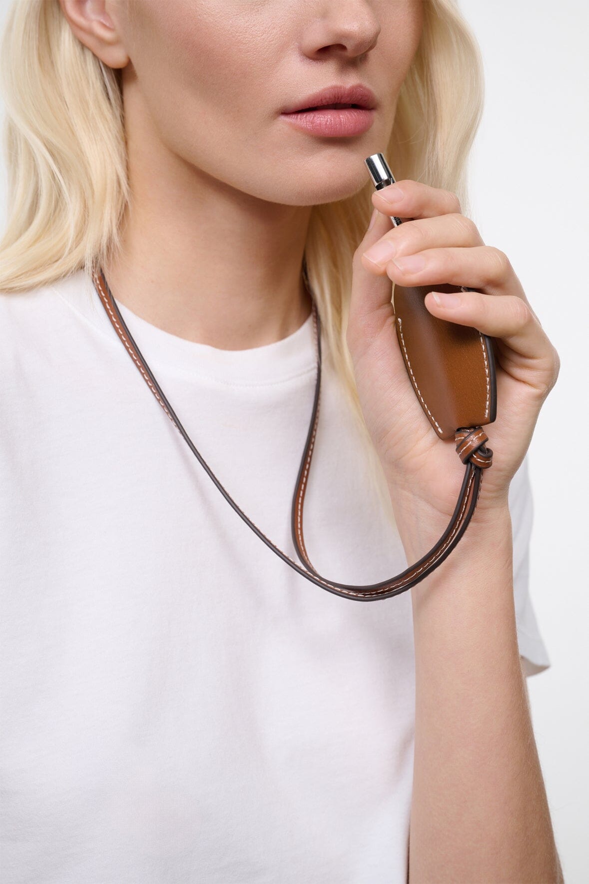 Tan-brown leather whistle pendant on cord with metal whistle detail