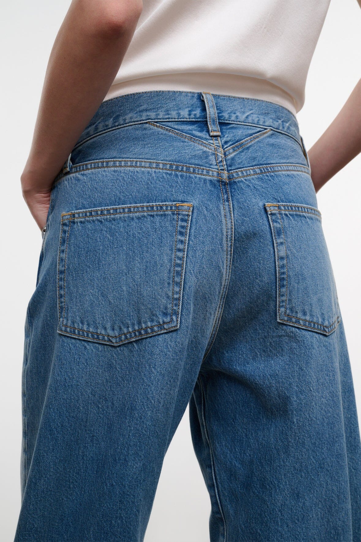 Medium-wash boyfriend jeans with back patch pockets and seam details