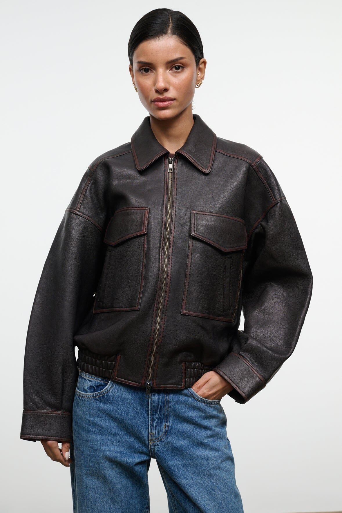 Distressed brown leather jacket with spread collar, zip front, and flap pockets