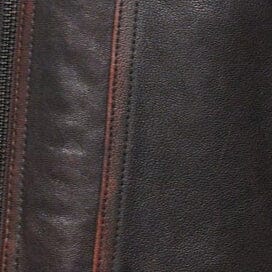 Distressed brown leather jacket close-up of front panels and stitched seam