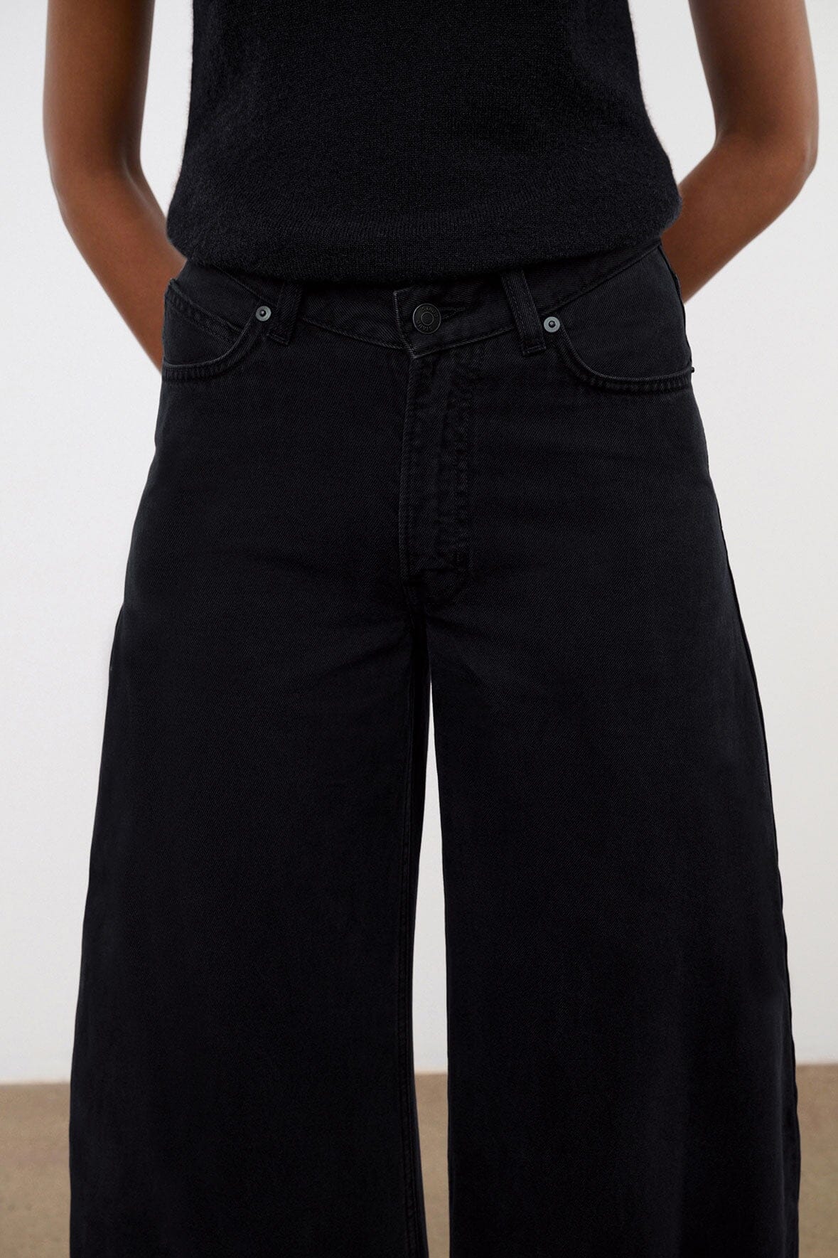 Black denim jeans with wide legs and front button fly