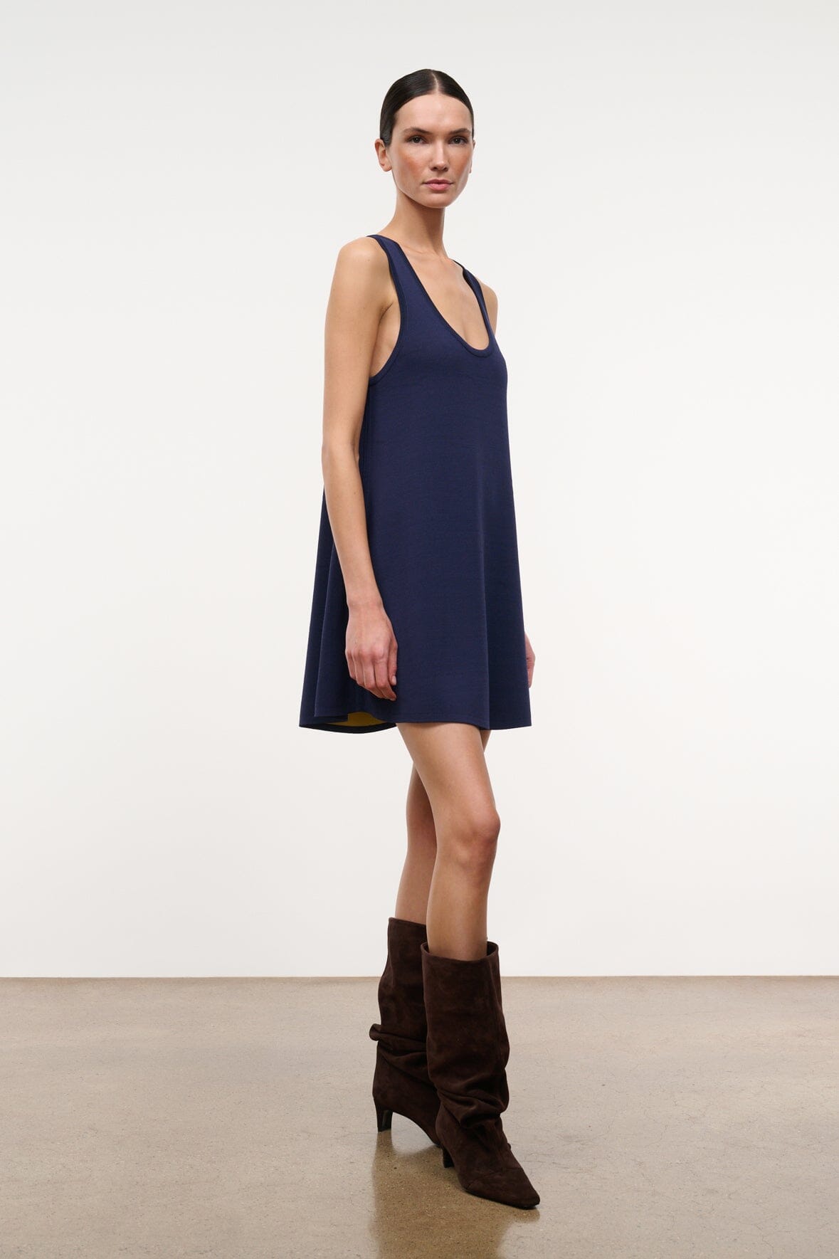 Sleeveless navy A-line dress with U neckline and navy trim at armholes