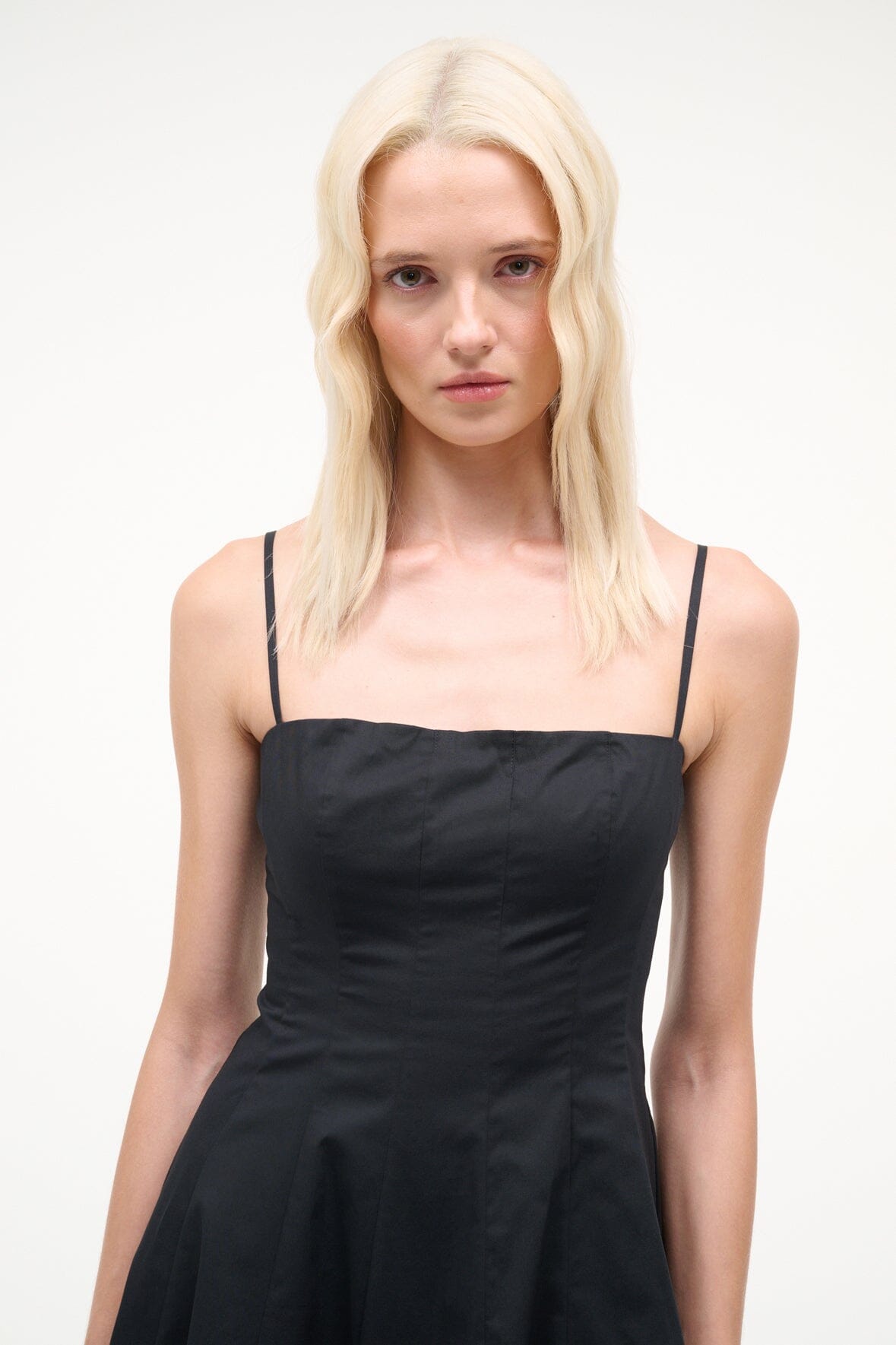 Black mini dress with spaghetti straps and square neckline, ruched fitted bodice