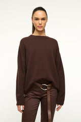 Mahogany brown leather wrap belt with silver oval buckle worn at the waist
