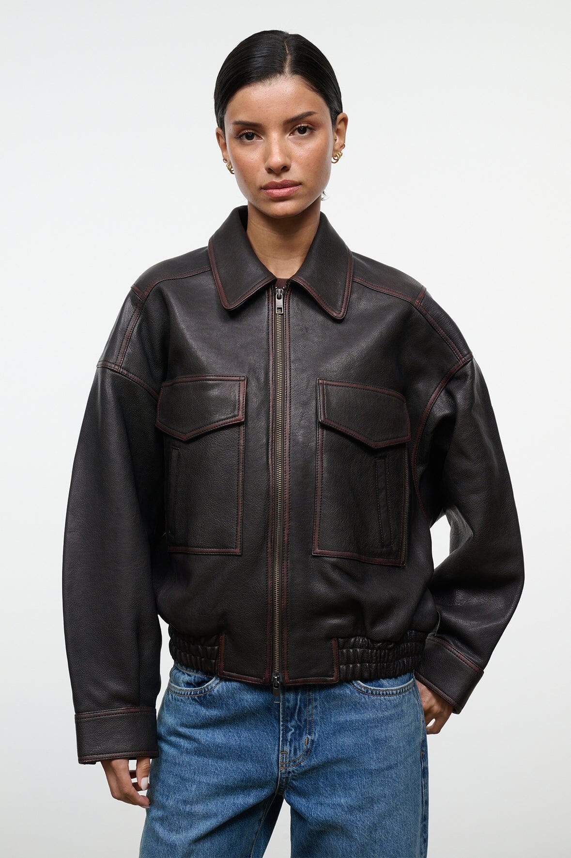 Distressed brown leather zip jacket with stitched flap pockets and elastic cuffs