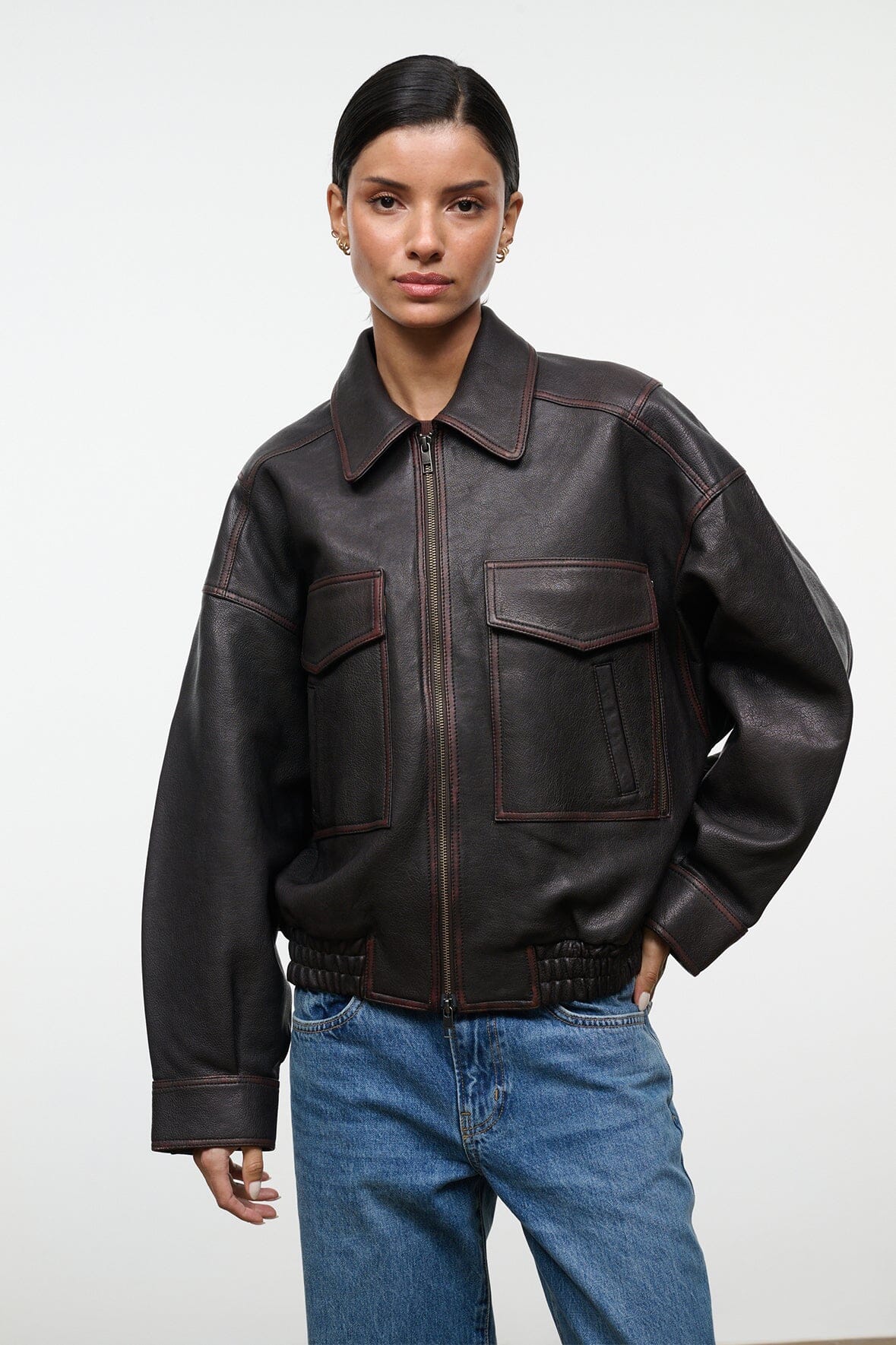 Distressed brown leather bomber-style jacket with zip front, flap pockets, elastic hem