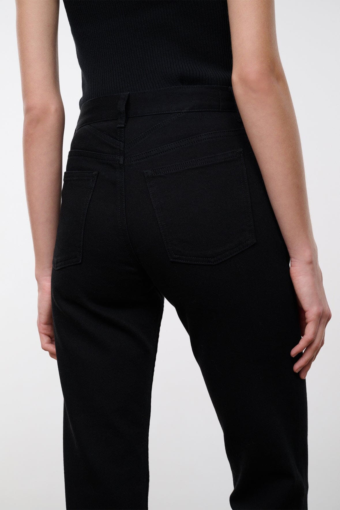 Black denim jeans back view with two back pockets and belt loops