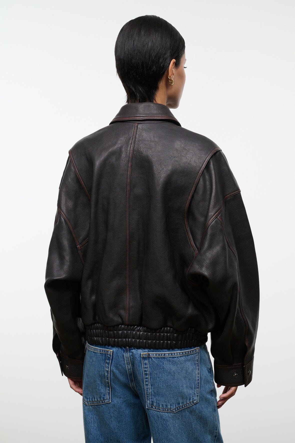 Distressed brown leather jacket back view with ribbed waistband and elastic cuffs