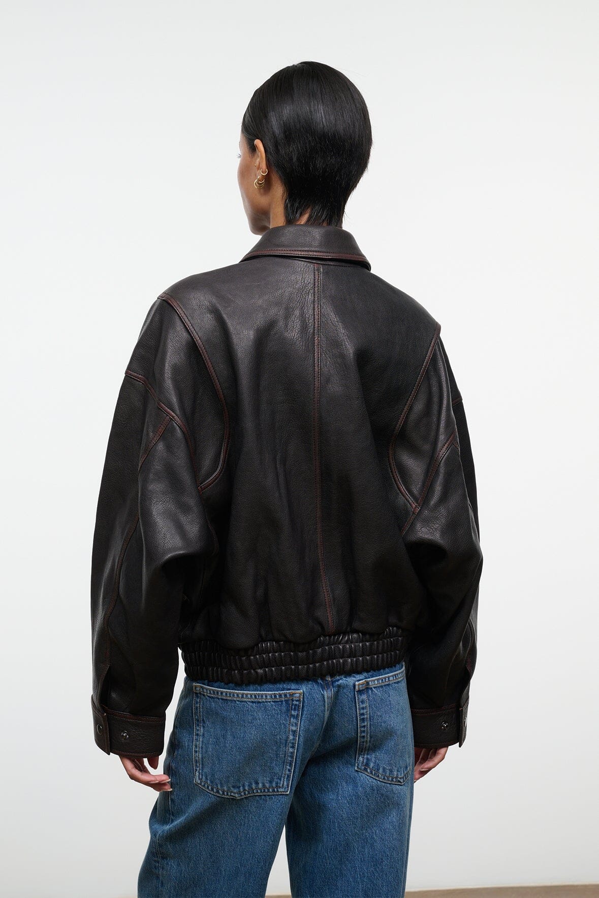Distressed brown leather jacket back view with yoke seams and elastic cuffs