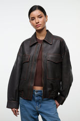 Distressed brown leather zip jacket with pointed collar, flap pockets, and elastic hem