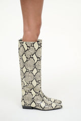Snake-print flat mid-calf boot on model with pointed toe and low block heel