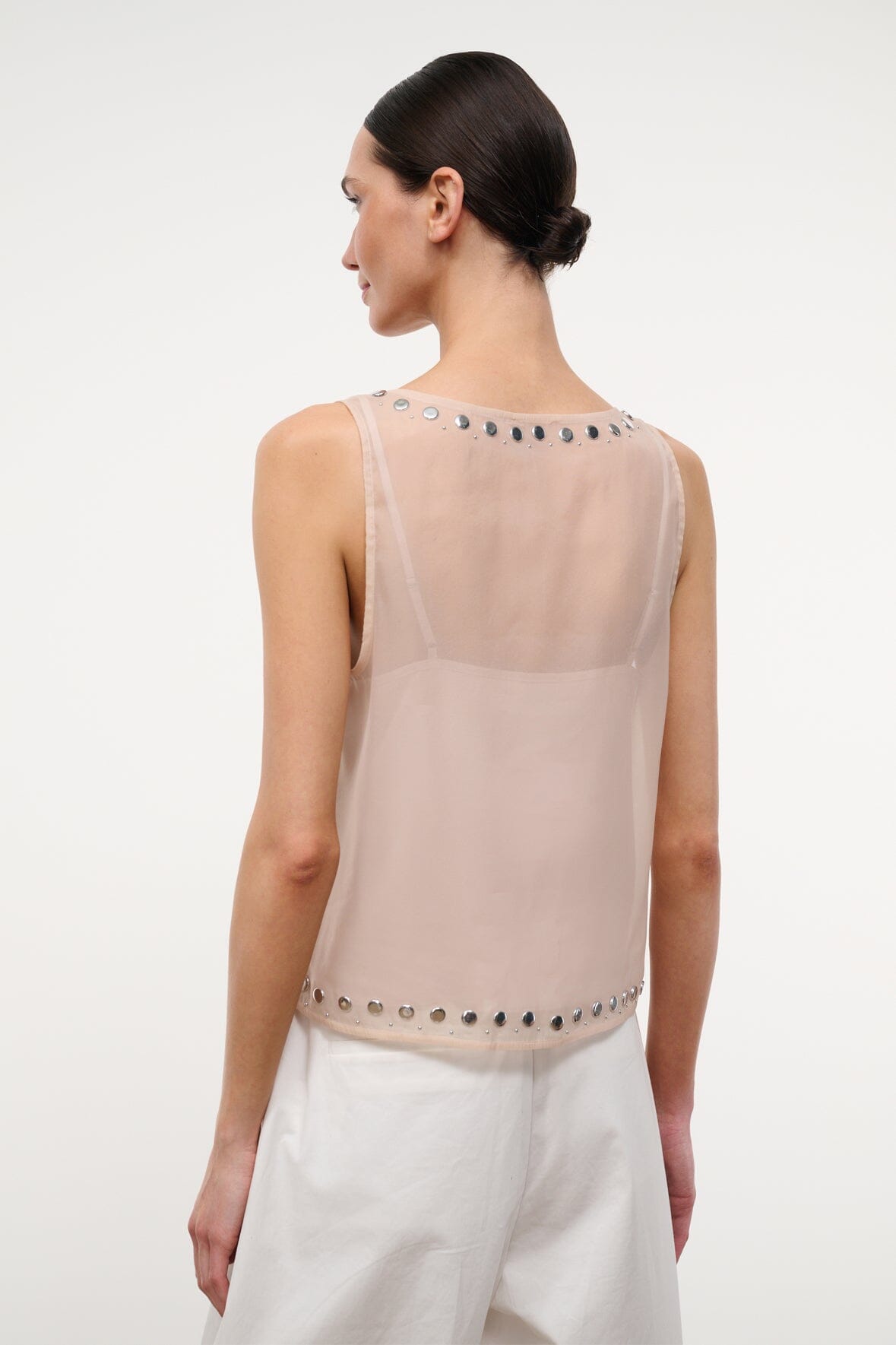Back of light pink studded tank top with vertical row of metal grommets