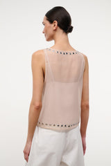Back of light pink studded tank top with vertical row of metal grommets