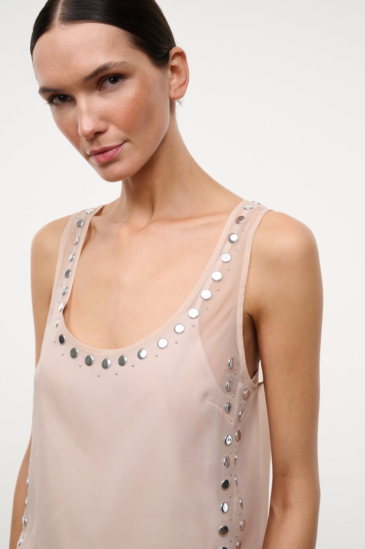 Light pink tank top with silver studs along U-neckline and side straps