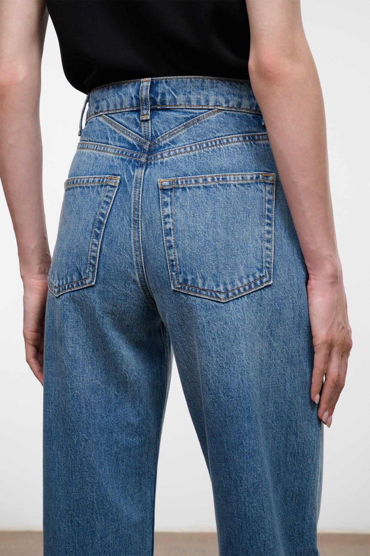 High-rise blue denim jeans with back yoke and two rear patch pockets.