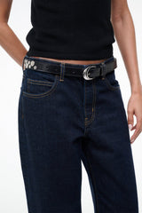 Black rivet belt with silver moon buckle on dark denim jeans waistband