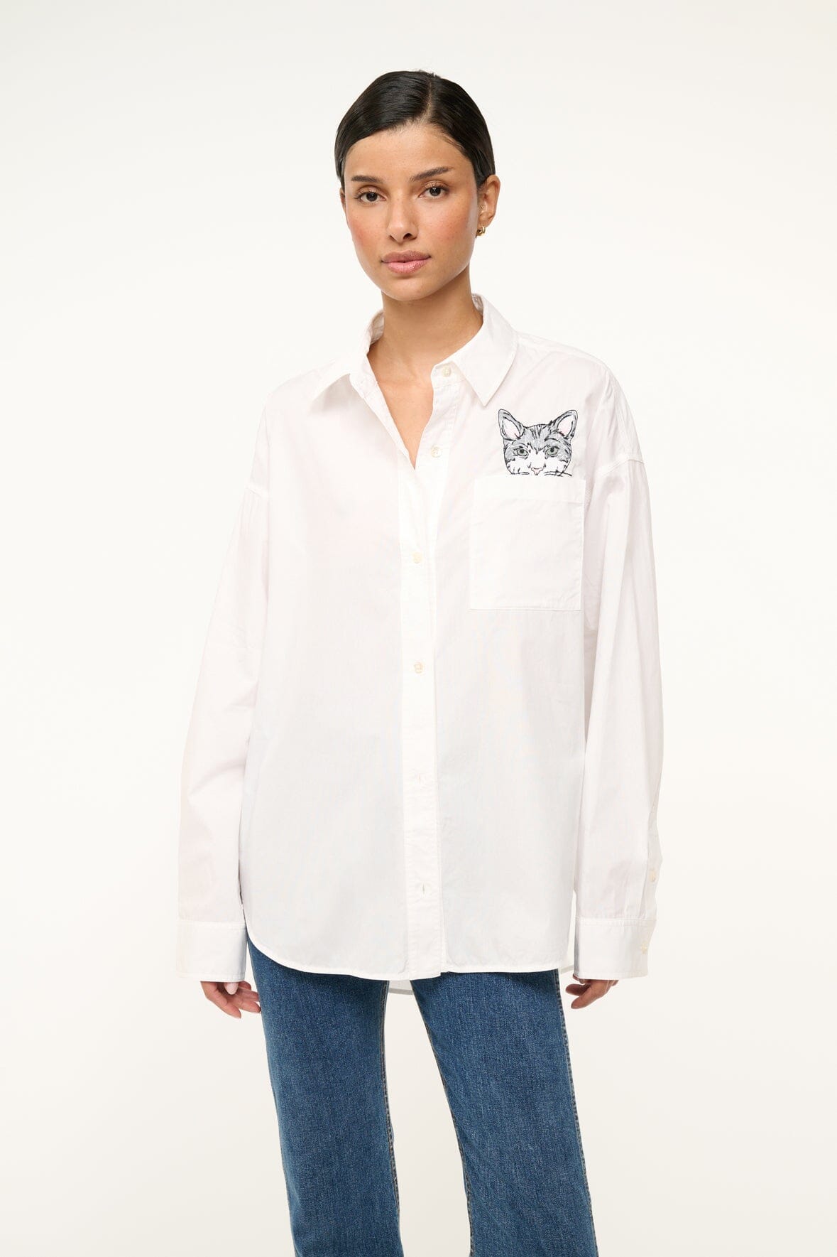 White oversized button-up shirt with cat graphic patch on chest pocket
