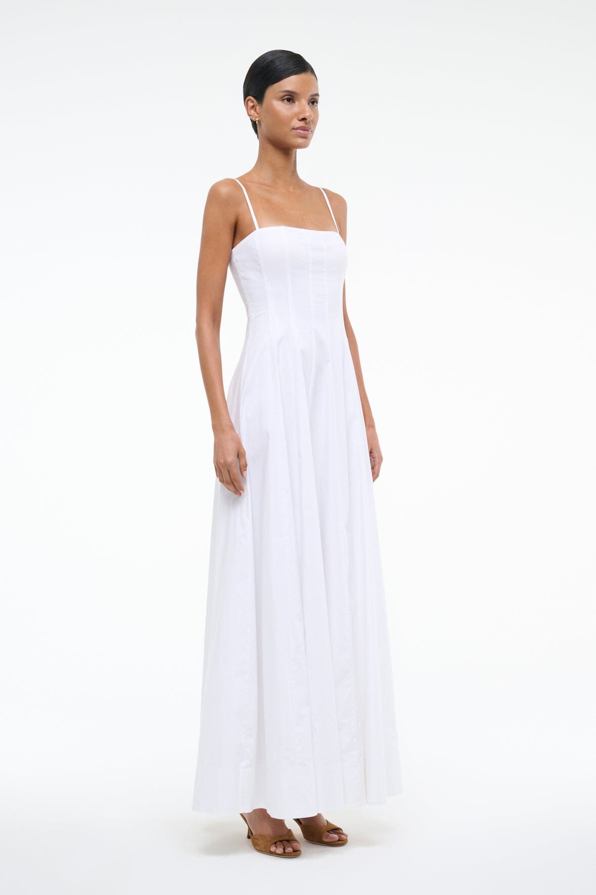 White maxi dress with spaghetti straps and square neckline, pleated skirt, side view