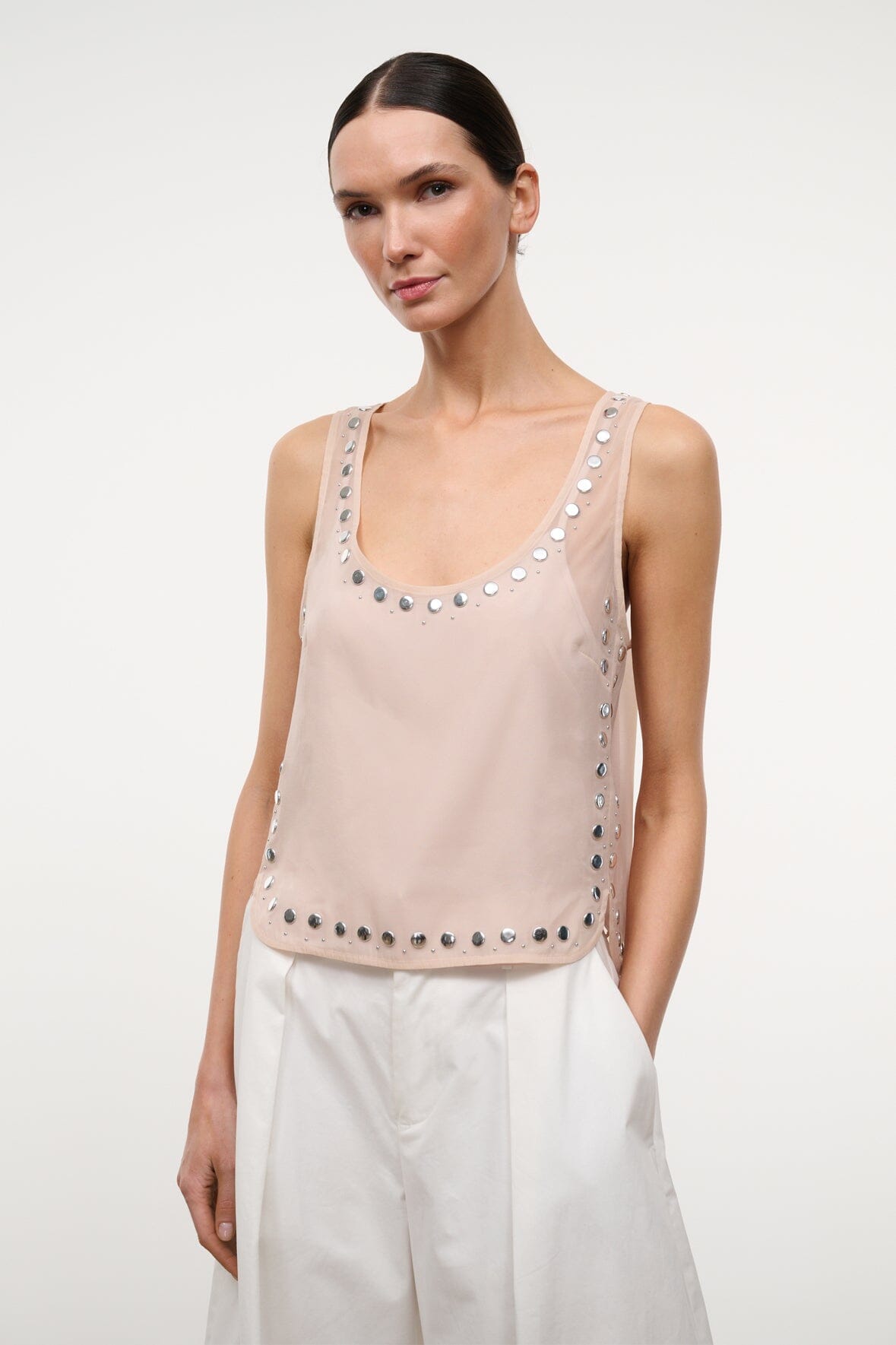 Light pink studded tank top with silver studs around neckline and lower edge