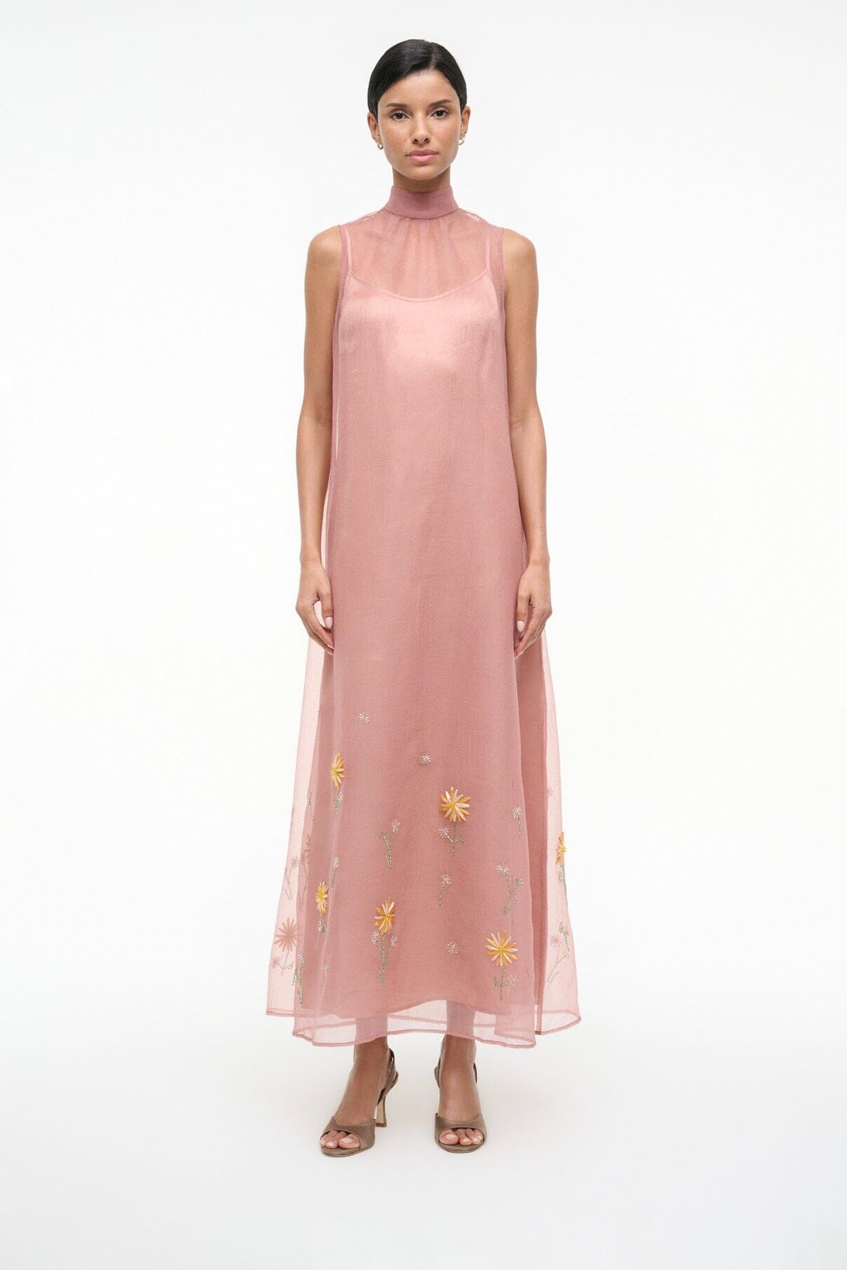 Heeled sandals on a model wearing a blush sleeveless sheer dress with yellow floral embroidery
