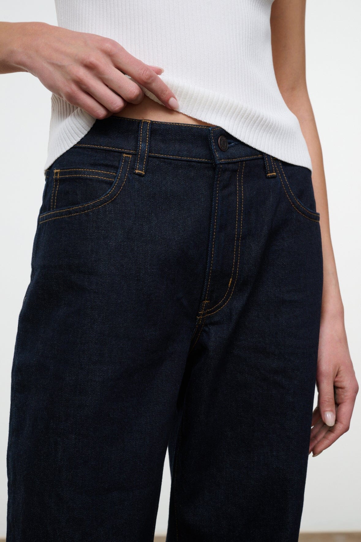 Indigo denim jeans with belt loops, button fly, and stitched front pockets.