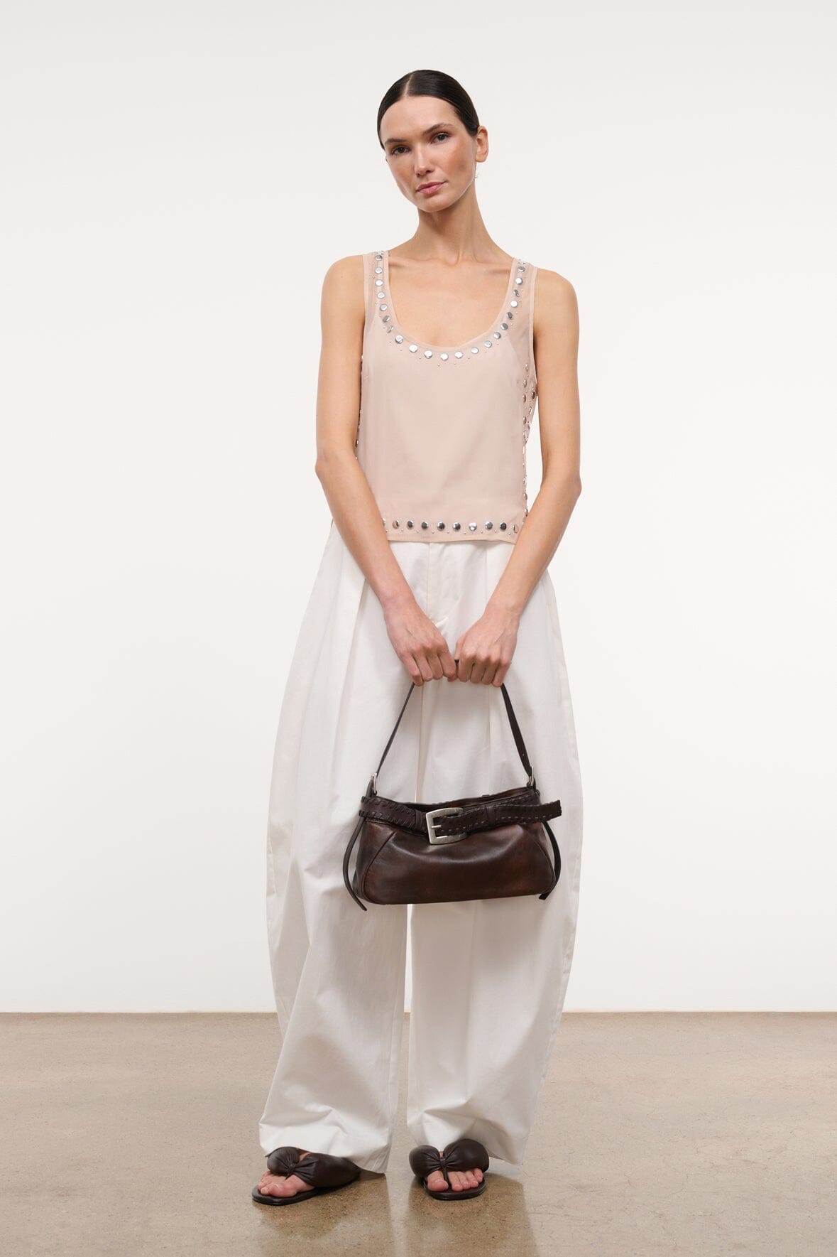 Light pink sleeveless tank top with silver stud trim at neckline and hem