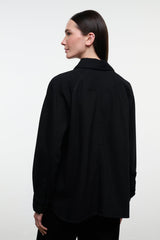 Black shirt jacket with stand collar and button front, long sleeves; back view.
