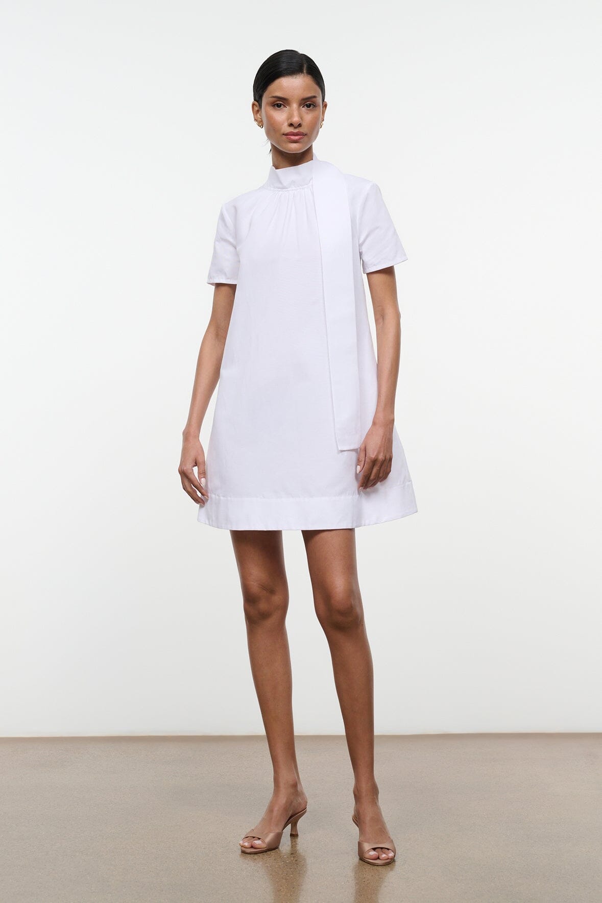 White mini dress with high neckline, short sleeves, and straight A-line skirt