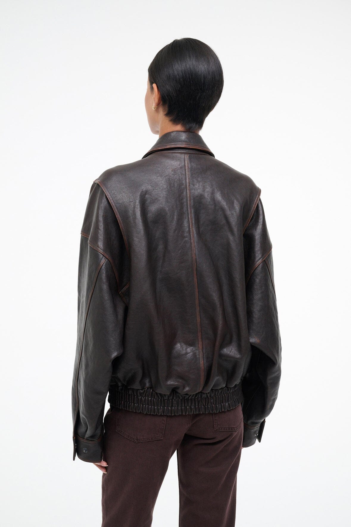 Distressed brown leather jacket back view with ribbed hem and center seam