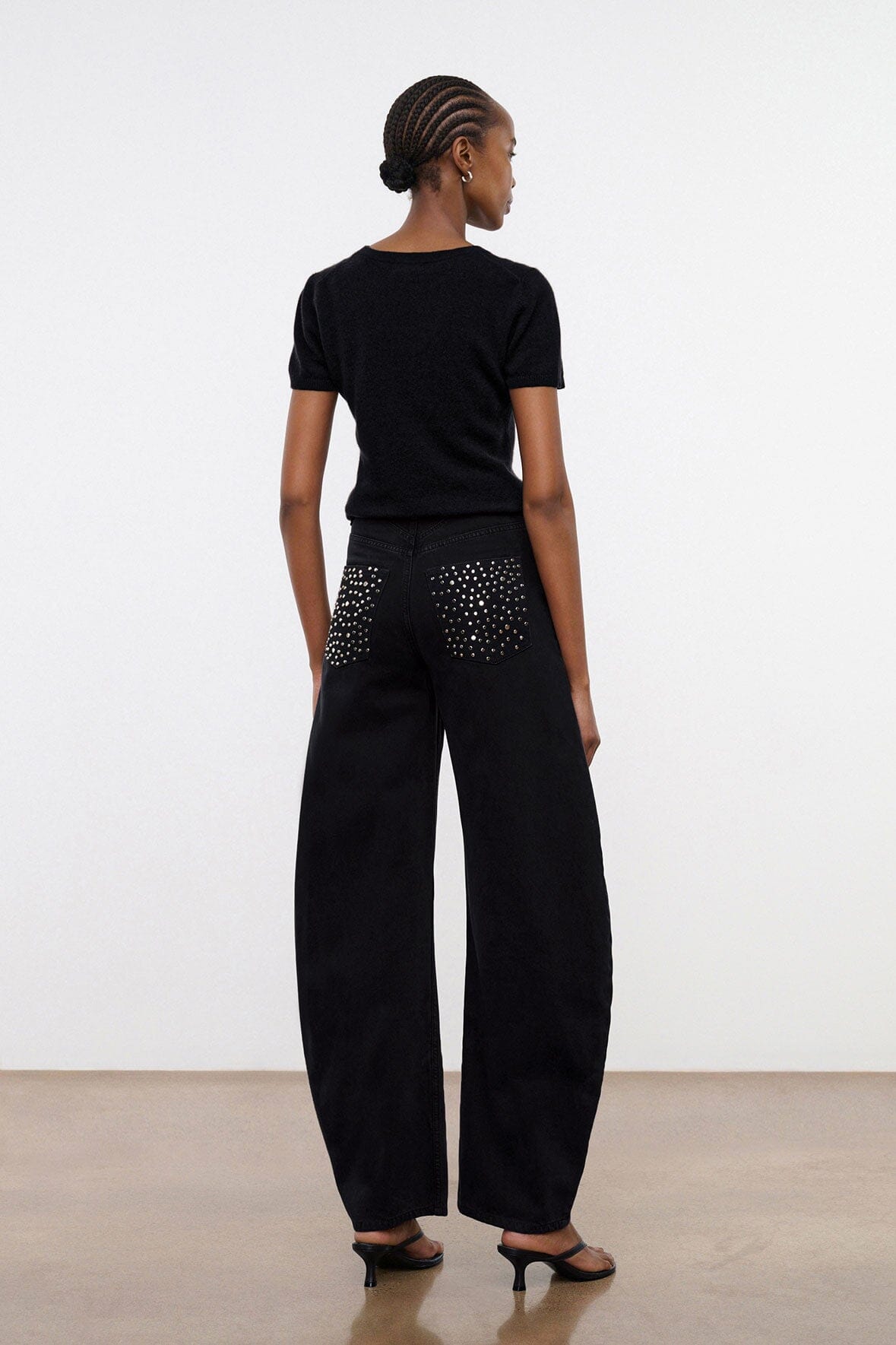 Black barrel jeans with studded back pockets, ankle-length