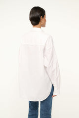 White oversized button-up shirt, back view with collar and curved hem