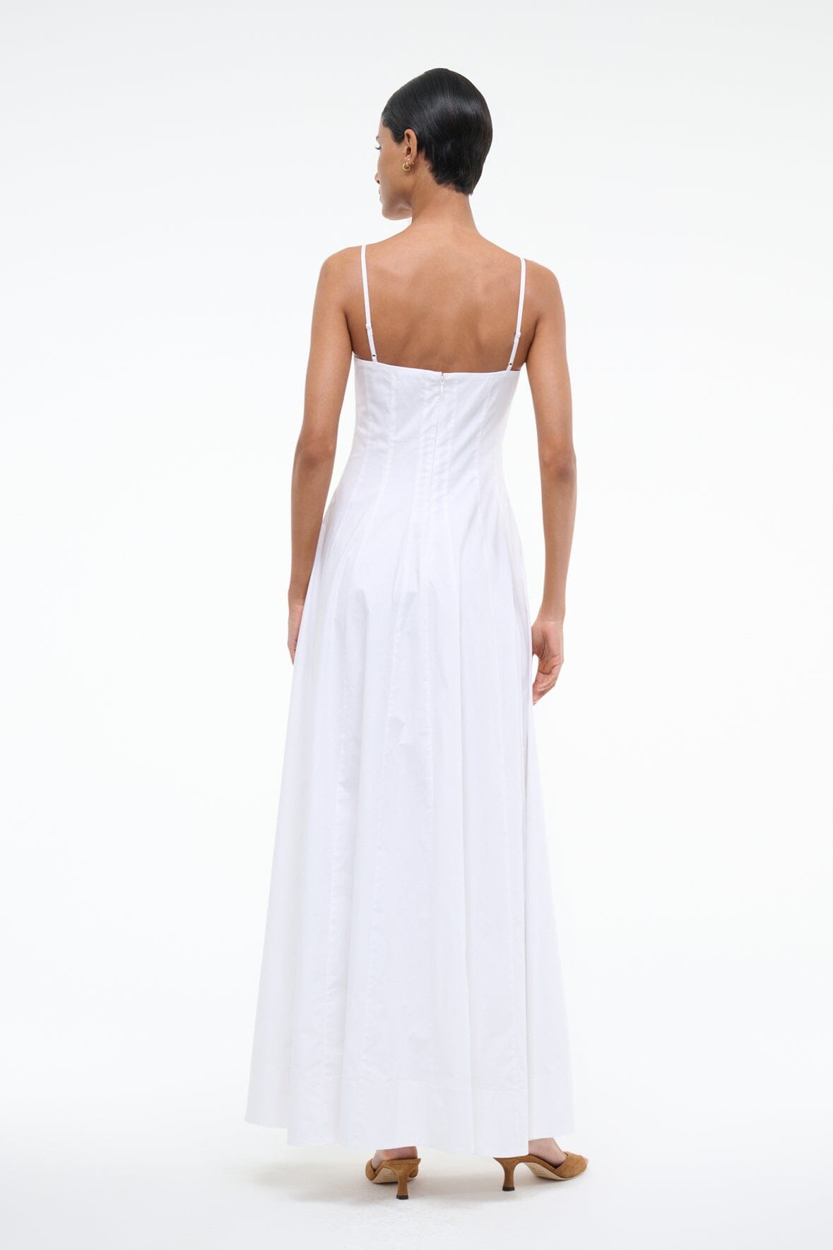 White maxi dress with spaghetti straps and open back, flowing pleated skirt