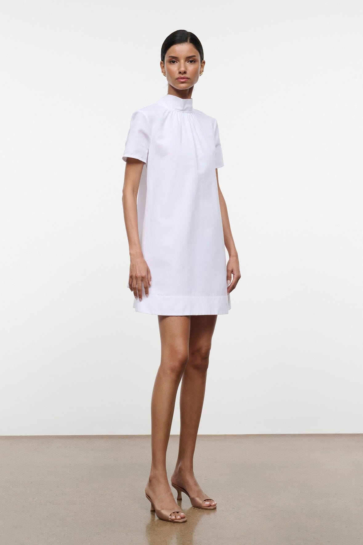 White mini shift dress with high neck, short sleeves, and straight hem